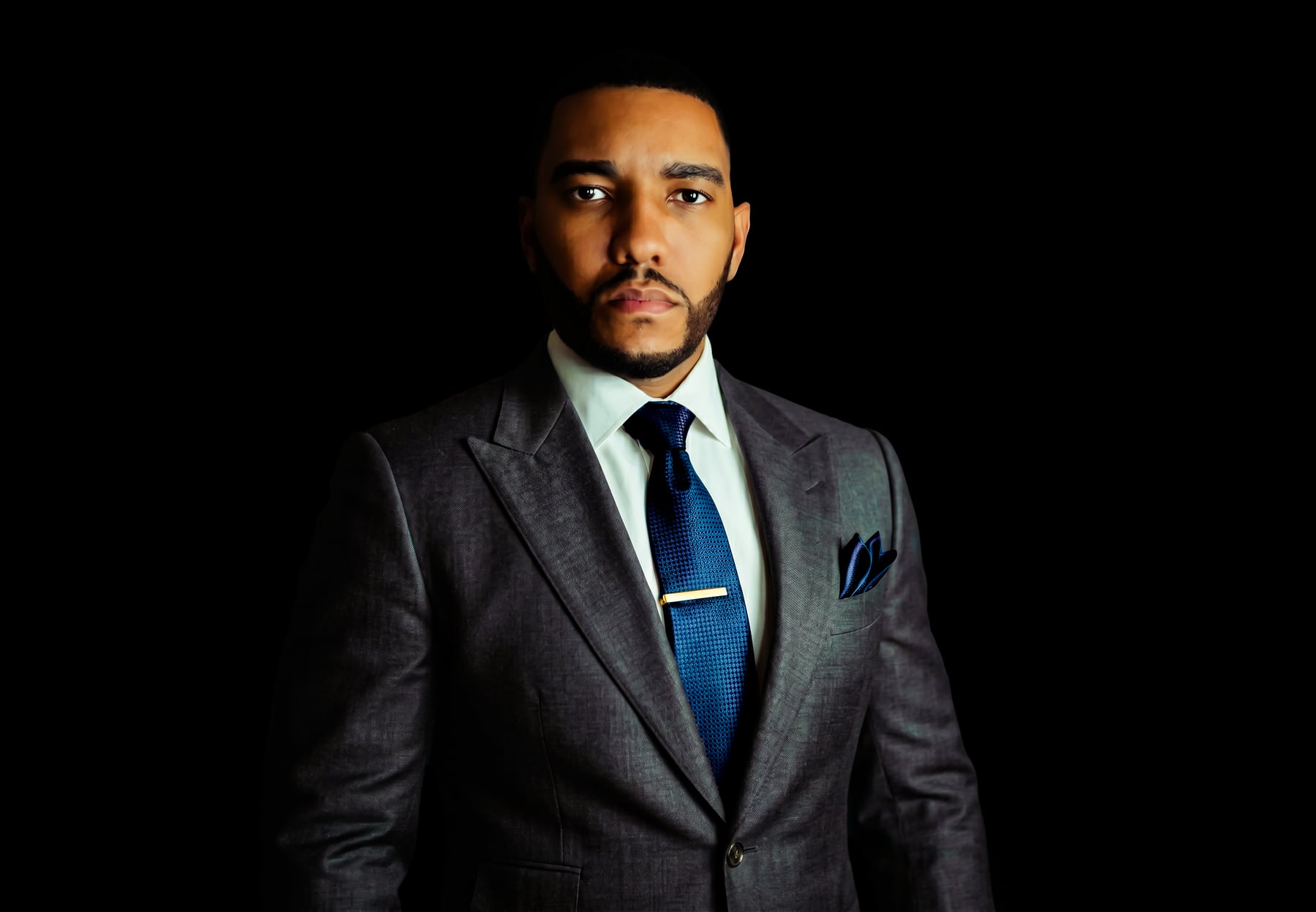 Michael Harte Jr. in a dark suit with blue tie and pocket square